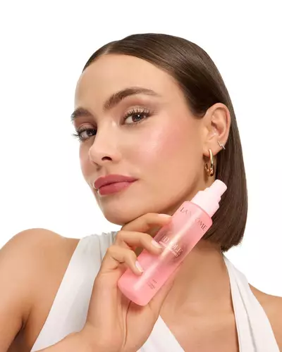 Kobieta z gładkim bobem trzymająca mgiełkę Lancome Idole.