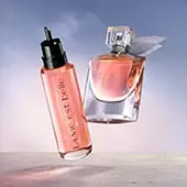 Flakony perfum w pastelowych odcieniach na tle delikatnej, kolorowej mgły.