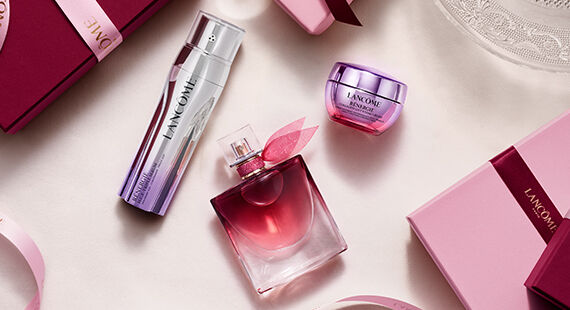 Świąteczne zestawy prezentowe Lancome w rożowych pudełkach w stylu vintage na tle ośnieżonych gor.