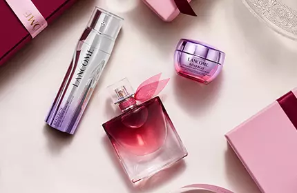 Świąteczne zestawy prezentowe Lancome w rożowych pudełkach w stylu vintage na tle ośnieżonych gor.