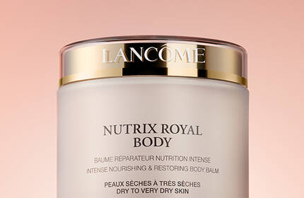 A close-up of a jar of Lancome Nutrix Royal Body cream against a soft, pink background.
