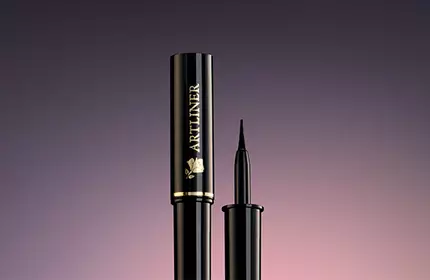 A sleek, black mascara tube and applicator against a gradient background.