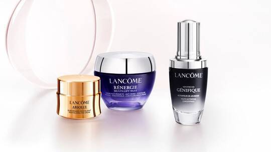 Trzy kremy do pielęgnacji skory marki Lancome: Absolue, Renergie Multi-Lift i Genifique, uporządkowane na jasnym tle.