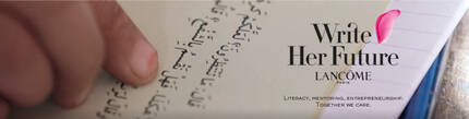 Na obrazku widoczna jest dłoń trzymająca kartkę z tekstem w języku arabskim, z logo kampanii "Write Her Future" marki Lancome w rogu.