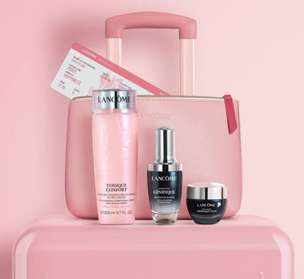 An arrangement of beauty products including a pink suitcase, a bottle of lotion, a serum, and a cream, all displayed against a soft pink background.