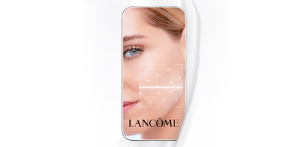 Aplikacja Lancome na telefonie, z kobiecą twarzą w tle, ukazująca jej oczy i gładką skorę.