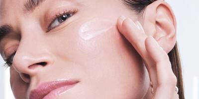 Kobieta nakładająca serum przeciw przebarwieniom na twarzy Lancome