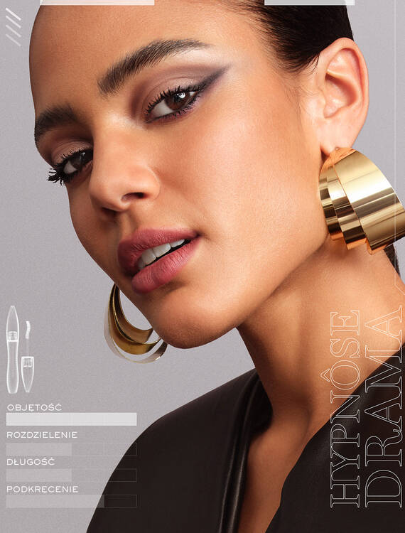 Portret młodej kobiety z wyrazistym makijażem, złotymi kolczykami i subtelnym uśmiechem. W tle widoczne elementy tekstowe dotyczące kosmetykow.