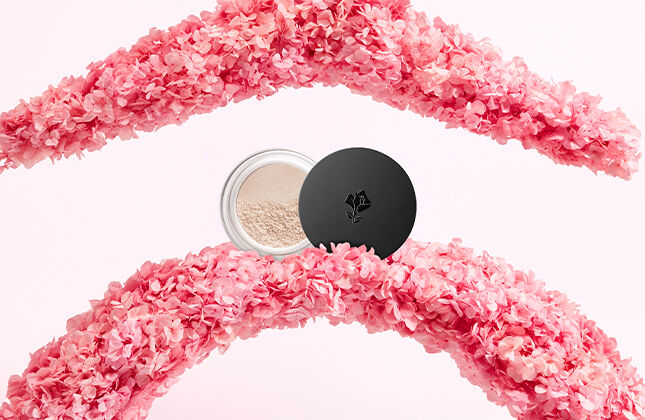 Kwiatowe kompozycje w odcieniach rożu z pudełkiem kosmetykow na środku.