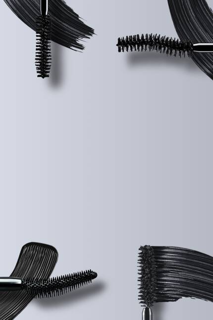 Cztery szczoteczki do tuszu do rzęs na szarym tle.