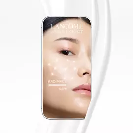 Zdjęcie przedstawia smartfon z aplikacją Lancome e-SKIN EXPERT, na ktorej widoczny jest zbliżony portret osoby oraz wskaźnik promienistości na poziomie 65%. W tle znajduje się biały, falisty wzor.