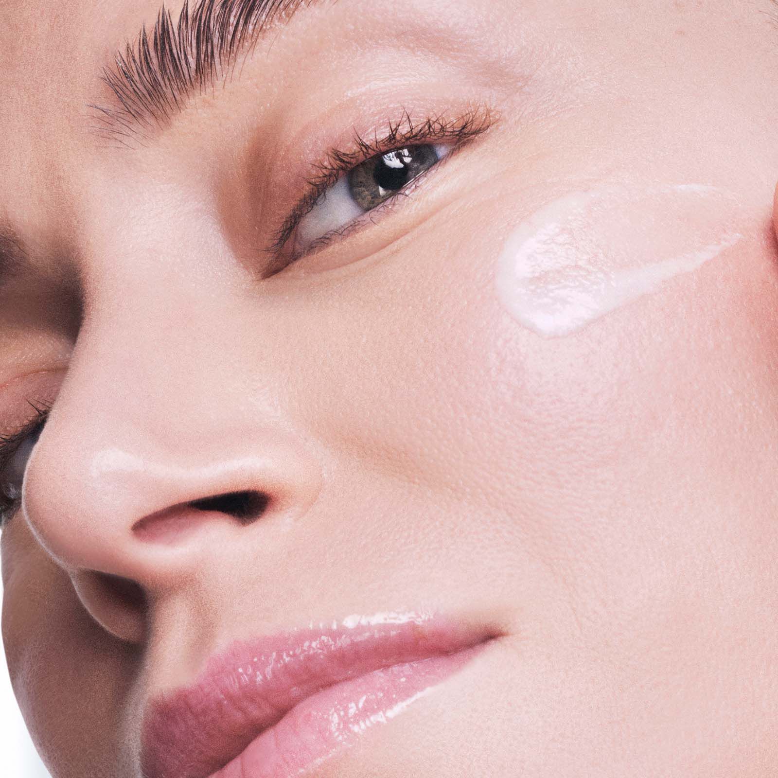 Kobieta nakładająca serum przeciw przebarwieniom na twarzy Lancome